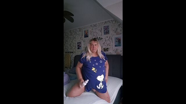 Пухлая блондинка-транс одна на своей кровати с большой пробкой